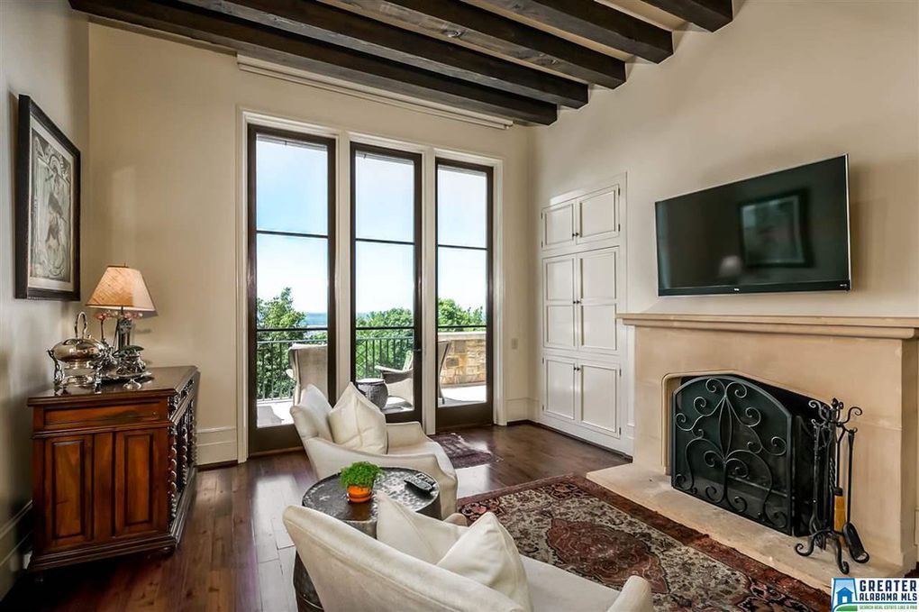 Cast stone mantel, soaring ceilings and windows, beams, and natural light