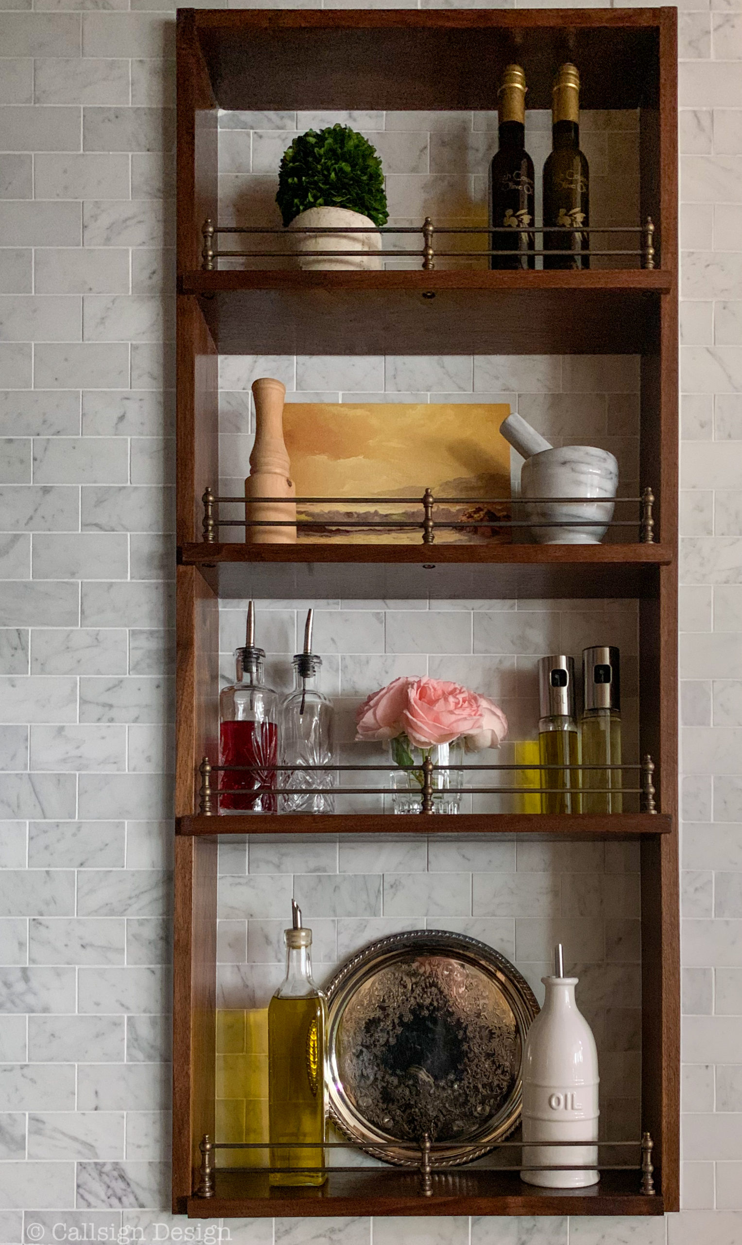 The Oil and Spice Shelf Nook Inside Your Range Hood Surround You Didn't Know You Needed But You Absolutely Must Have: Styled shelfie all ready to go with a small preserved boxwood, oils from High Country Olive Oil, a carrara marble mortar and pestle, a vintage landscape oil painting, oil carafes/dispensers, and a tiny votif of roses from our last bloom of the season